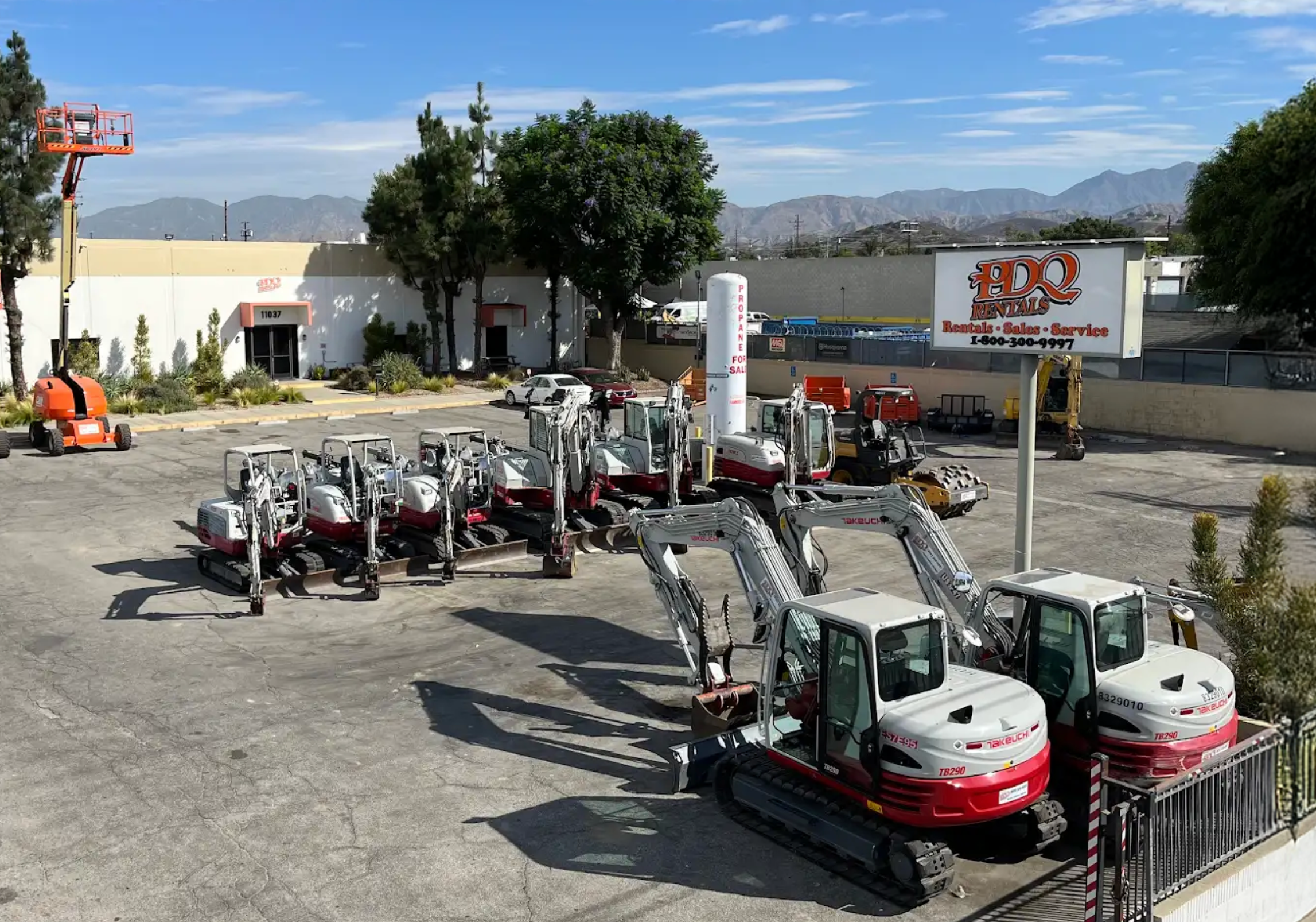 PDQ Rentals yard in Sun Valley with excavators and a boom lift