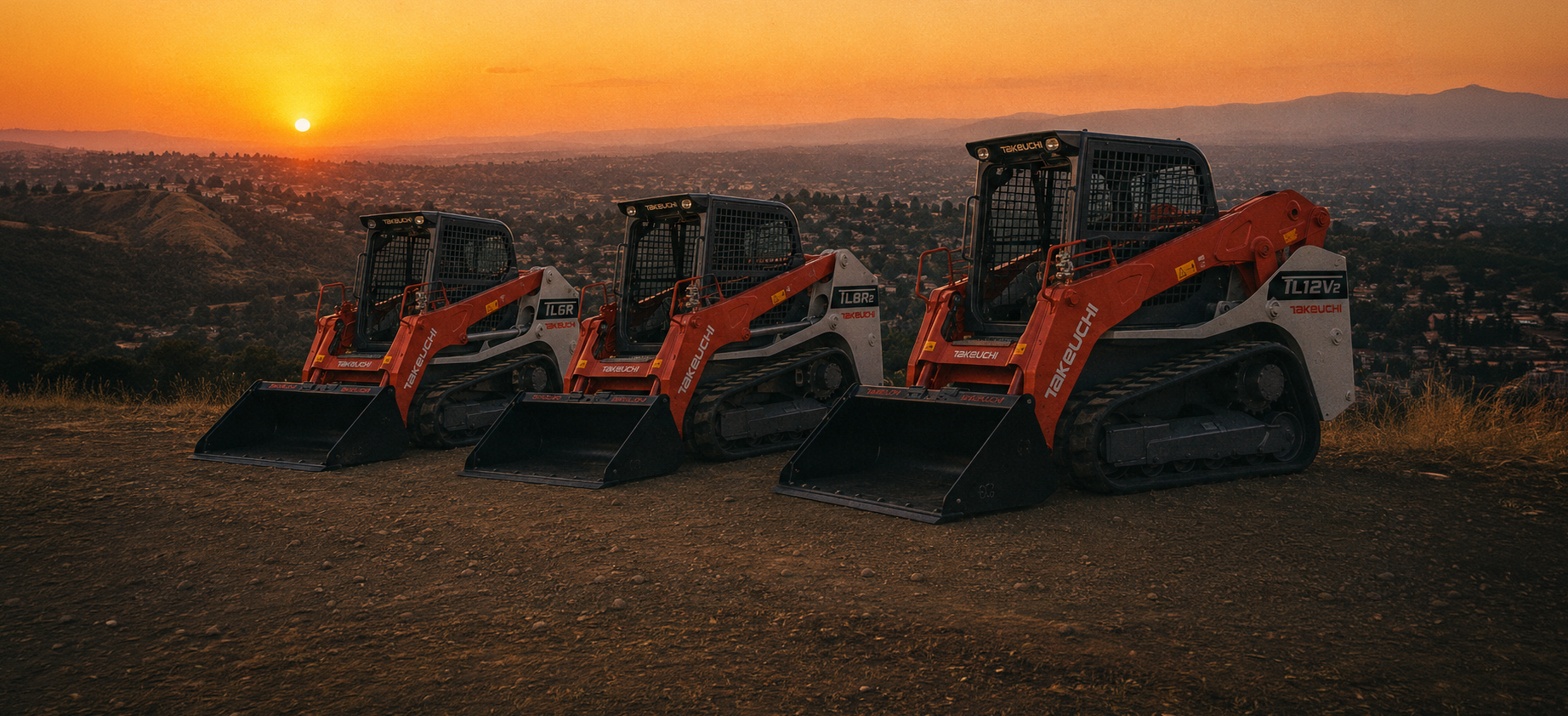 Three Takeuchi track loaders on a hillside at sunset