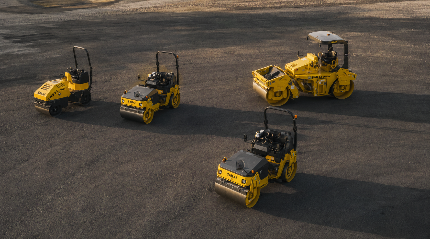 Four Sakai rollers parked on an asphalt lot